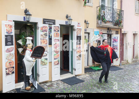 1. März 2018: Lissabon, Portugal - eine junge Frau zieht das Geschäft außerhalb Restaurant Guerreiro in Lissabon Altstadt. Sie ist mit einem Stück... Stockfoto