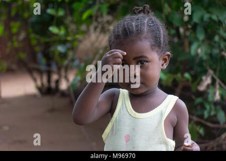 Nervösen jungen afrikanischen Mädchen spielen mit Haar. Stockfoto