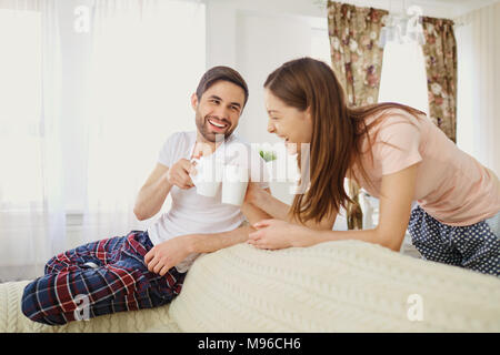 Ein Mädchen und ein Kerl mit einer Fernbedienung Fernsehen sitzen auf dem Sofa im Zimmer. Stockfoto