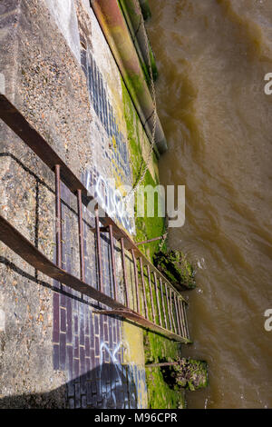 Eine rostige alte Leiter auf das Meer bei Ebbe auf der Themse im Zentrum von London. Atmosphärische und geheimnisvolle Atmosphäre und Geheimnis in der Stadt. Stockfoto