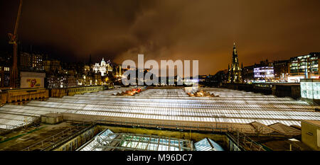 Panoramablick über dem Bahnhof Waverley, Edinburgh in der Nacht. Stockfoto