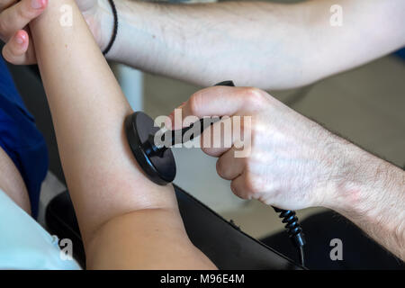 Physiotherapeut tun Tecar Therapie (Radio Frequency Transporter) alterantive Behandlung auf einer Patientin Stockfoto