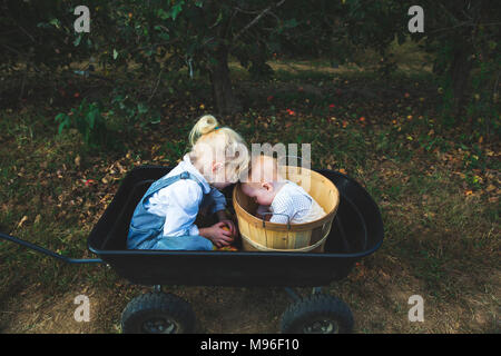 Mädchen und Baby zusammen in Orchard Körbe Stockfoto