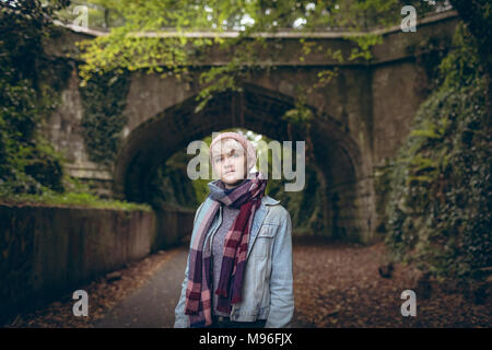 Nachdenkliche junge Frau in warme Kleidung stehen auf Pfad Stockfoto