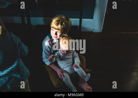 Babysitting auf Boy's Lap Stockfoto