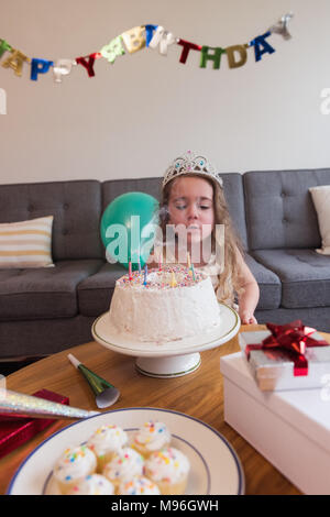 Kleines Mädchen Ausblasen der Kerzen auf der Geburtstagstorte Stockfoto