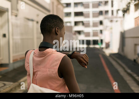 Frau Kontrolle der Zeit auf ihr Ansehen in der Stadt. Stockfoto
