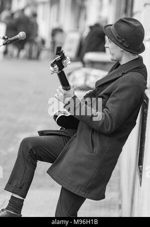 Porträt einer männlichen Straßenmusiker unterhalten der Öffentlichkeit als die Gaukler Gitarre in Brighton, East Sussex, England, Großbritannien spielt. Stockfoto