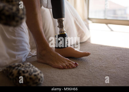 Frau mit beinprothese im Schlafzimmer zu Hause Stockfoto