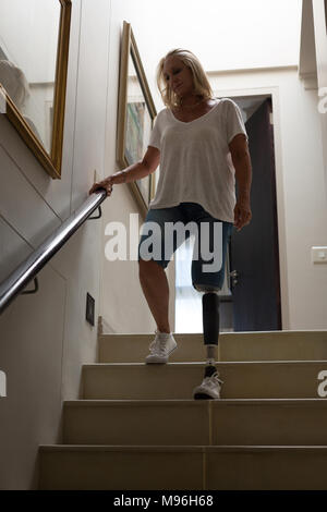 Reife Frau mit beinprothese von den Treppen nach unten bewegt Stockfoto