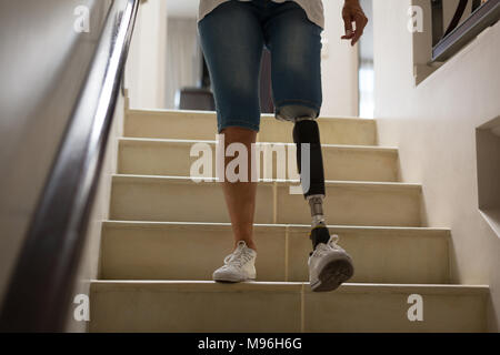 Reife Frau mit beinprothese von den Treppen nach unten bewegt Stockfoto
