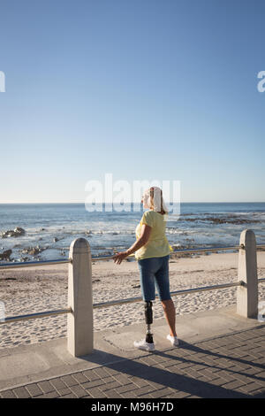 Behinderte Frau, die in der Nähe von Strand Stockfoto