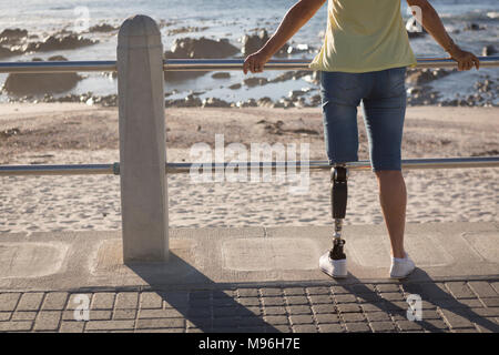 Behinderte Frau, die in der Nähe von Strand Stockfoto