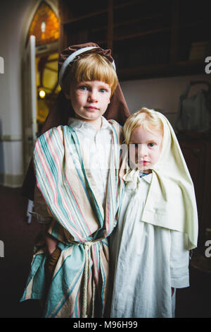 Kinder, die an der Kamera im Pageant Kostüme Stockfoto