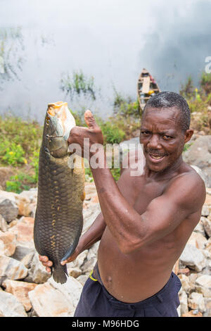 Kojo halten seinen Fang auf der Bank der Akosombo Damm, südlichen Ghana. In Ghana, Kinder werden häufig ein 'Day', der dem Tag entspricht in der Woche sie geboren wurden. Darüber diesen Tag Namen haben auch Bedeutung für die Seele und den Charakter der Person. Zum Beispiel Kojo bedeutet Montag geboren und Frieden in der lokalen Sprache Akan. Stockfoto
