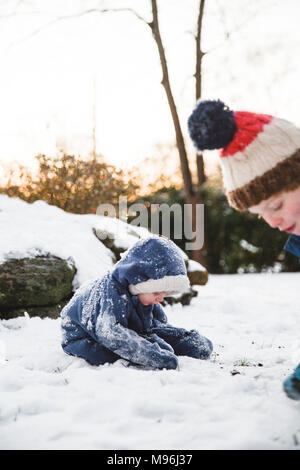 Zwei Jungen, die im Schnee spielen, Macht Schneebälle Stockfoto