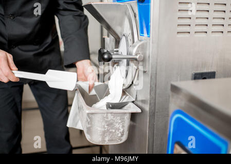 Koch, weißes Eis aus der Eismaschine Maschine in dem kleinen Fertigung Stockfoto