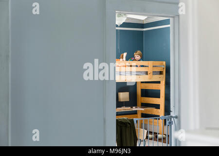 Junge auf Etagenbett lesen Stockfoto