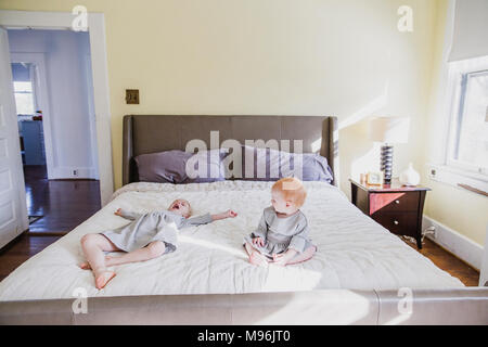 Mädchen und Baby spielt auf dem Bett Stockfoto