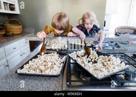 Kinder aufnehmen Popcorn aus Fach Stockfoto