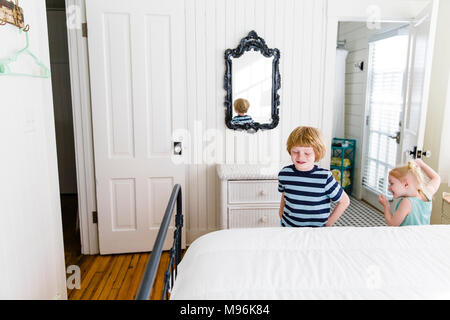 Zwei Kinder neben weißen Bett im Weißen Haus spielen Stockfoto
