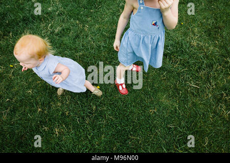 Baby und stehendes Mädchen im Feld Stockfoto