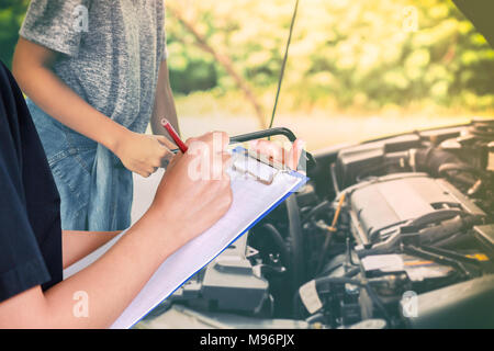 Asiatische Frauen Ingenieure und Techniker prüfen Mechaniker und Inspektion an einem Auto in der Autowerkstatt die Liste auf dem Brett Stockfoto