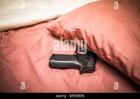 Unter dem Bett Kissen Gewehr für den persönlichen Schutz ausgeblendet Stockfoto