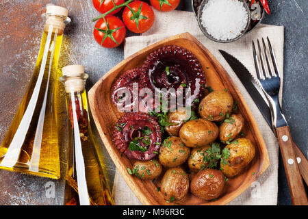 Gegrillter Tintenfisch mit kleinen Kartoffeln mit Kräutern und Gewürzen. Ansicht von oben Stockfoto