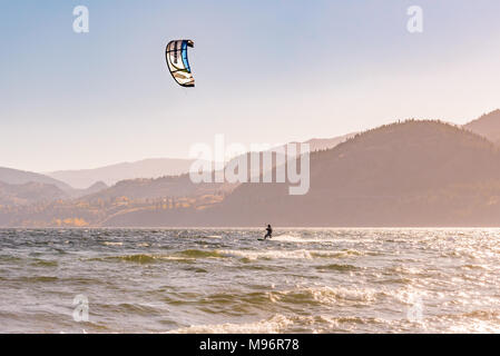 Mann auf einem Kiteboard surft auf Skaha Lake in Penticton, British Columbia, Kanada, an einem sonnigen Herbsttag. Stockfoto