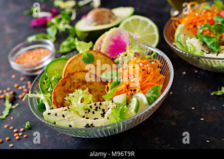 Vegan buddha Schüssel Abendessen Lebensmittel Tabelle. Gesundes Essen. Gesund vegan Mittagessen Schüssel. Omelett mit Linsen und Rettich, Avocado, karottensalat. Stockfoto