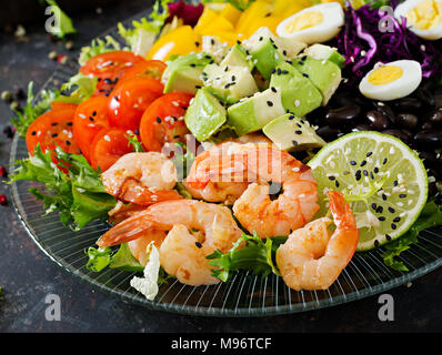 Gesunde Salatteller. Frische Meeresfrüchte Rezept. Gegrillte Garnelen und frisches Gemüse - Salat, Avocado, Tomate, schwarze Bohnen, Rotkohl und Paprika. Gegrillte Stockfoto
