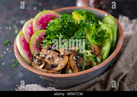 Vegan buddha Schüssel Abendessen Lebensmittel Tabelle. Gesundes Essen. Gesund vegan Mittagessen Schüssel. Gegrillte Champignons, Brokkoli, Rettich Salat Stockfoto