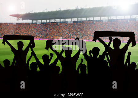 Silhouetten von Fußball-Fans in einem Match und Zuschauer im Fußballstadion Stockfoto