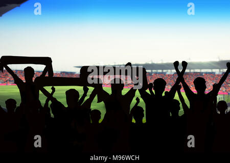 Silhouetten von Fußball-Fans in einem Match und Zuschauer im Fußballstadion Stockfoto