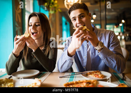 Schließen Sie herauf Foto der jungen Paare genießen in Pizza, zusammen Spaß zu haben. Konsum, Nahrung, Lifestyle Konzept Stockfoto