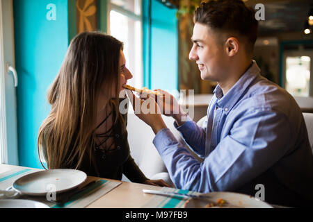Dating in der Pizzeria. Schön lächelnde Paare genießen in Pizza, zusammen Spaß zu haben. Konsum, Nahrung, Lifestyle Konzept Stockfoto