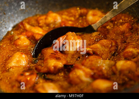 Nahaufnahme von karamellisierten Chicken Wings in einem Wok kochen, thai Rezept Stockfoto