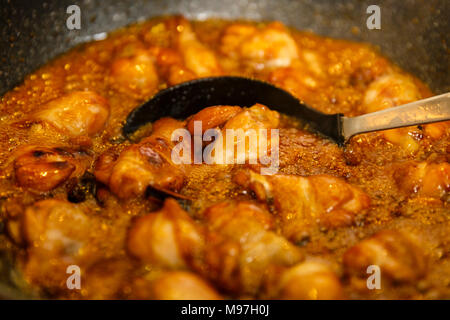 Nahaufnahme von karamellisierten Chicken Wings in einem Wok kochen, thai Rezept Stockfoto