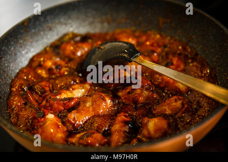 Nahaufnahme von karamellisierten Chicken Wings in einem Wok kochen, thai Rezept Stockfoto