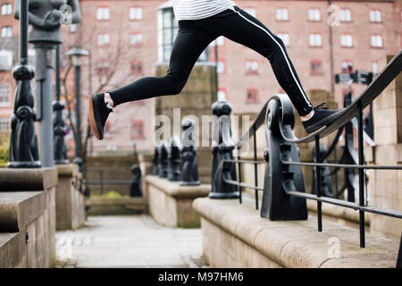 Nahaufnahme von einem freerunners Beine, wie er springt zwischen Geländer und Wände in der Stadt. Stockfoto