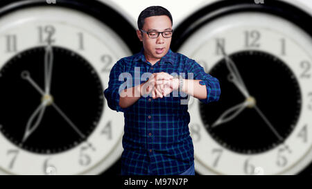 Porträt einer asiatischen jungen Mann zu spät zur Arbeit Konzept mit Uhr Hintergrund Stockfoto