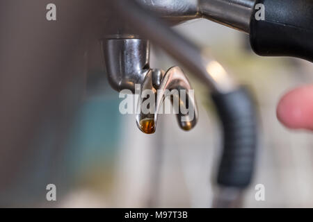 Frischen espresso tropft vom portafilter der Kaffeemaschine in weißen Schale Stockfoto