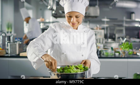 In einem berühmten Restaurant weiblichen Koch bereitet Salat. Sie arbeitet in einem großen, modernen Küche. Stockfoto