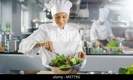 In einem berühmten Restaurant weiblichen Koch bereitet Salat. Sie arbeitet in einem großen, modernen Küche. Stockfoto