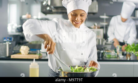 In einem berühmten Restaurant weiblichen Koch bereitet Salat. Sie arbeitet in einem großen, modernen Küche. Stockfoto