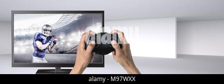 Hände halten Gaming Controller mit American football player im Fernsehen Stockfoto