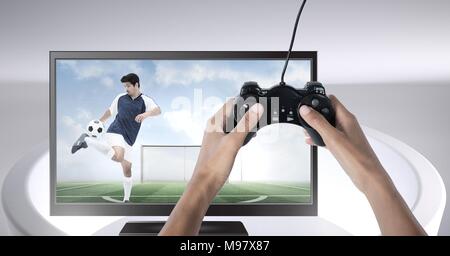 Hände halten Gaming Controller mit Fußball-Spieler im Fernsehen Stockfoto
