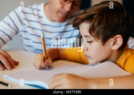 Vater, Sohn Hausaufgaben am Tisch Stockfoto