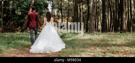 Rückansicht der Braut und Bräutigam walking im Wald Stockfoto